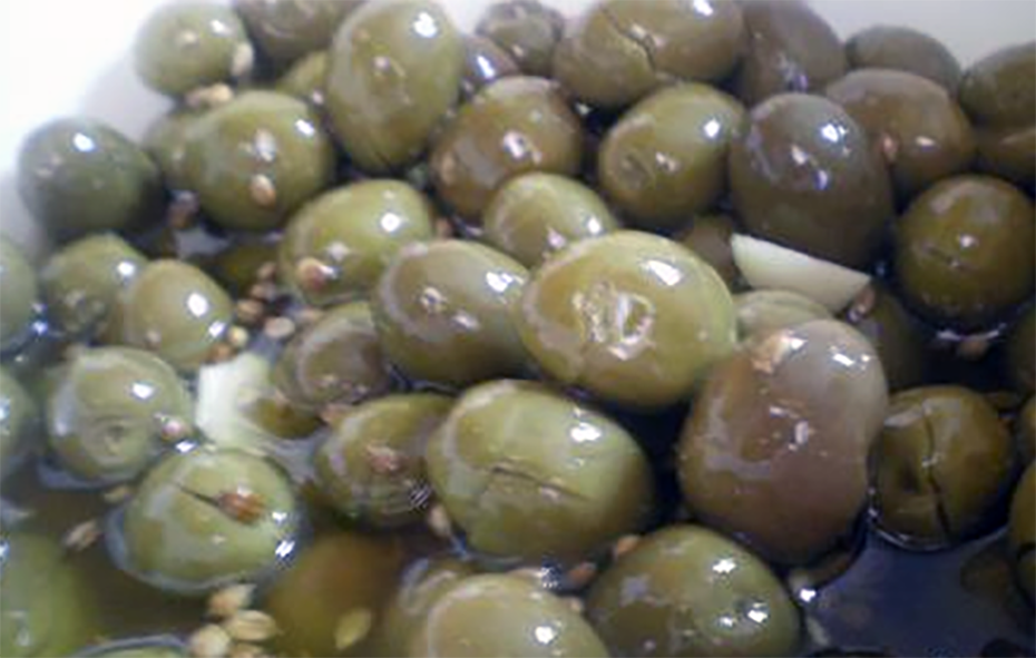dried and crushed olives preserved in brine and olive oil served in a bowl with garlic