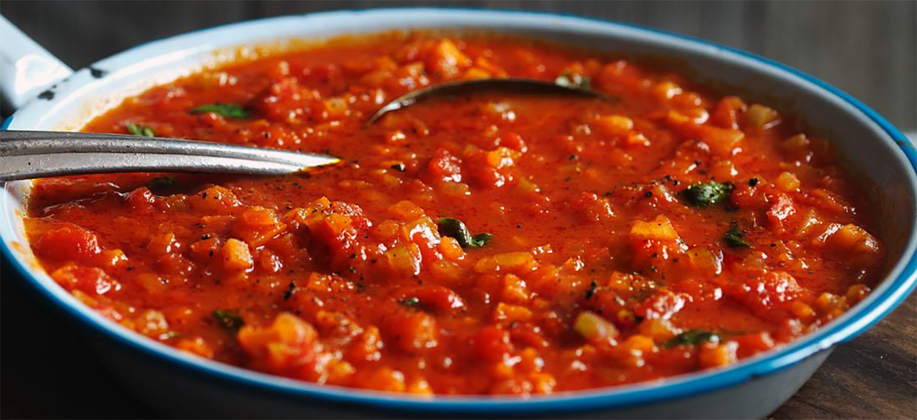 family spaghetti sauce in a steel pan with a metal spoon