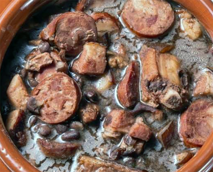 mixed meat and black bean stew in an earthenware casserole