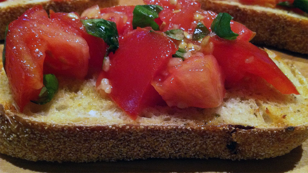 toasted ciabatta bread topped with tomato and torn basil