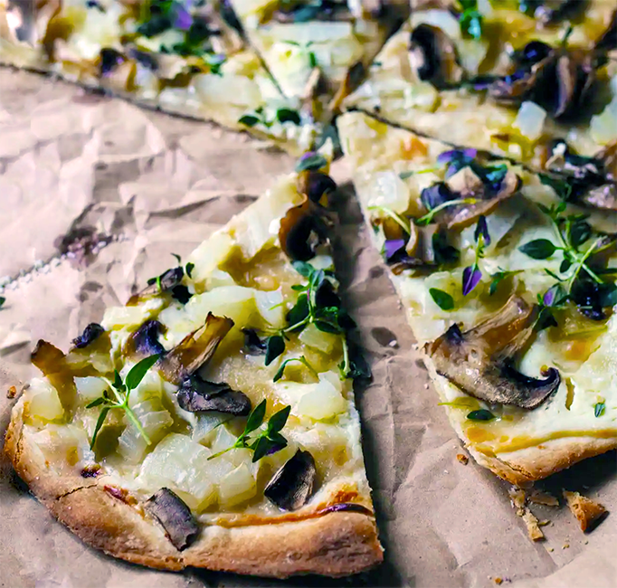 slices of German Christmas flammkuchen on a bed of baking parchment