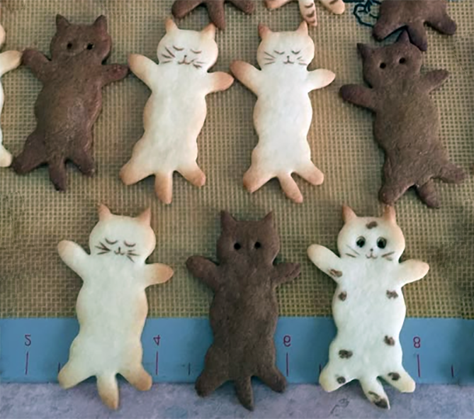 cookies in the shape of black and white squashed cats