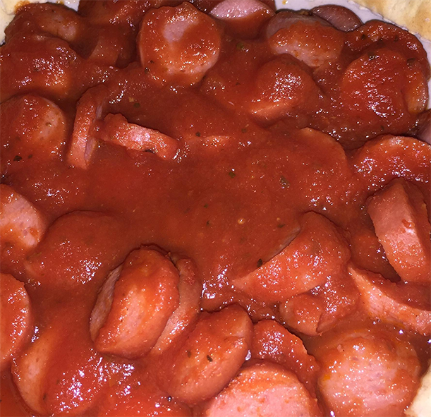 frankfurter slices in a spicy tomato sauce arranged on a plate
