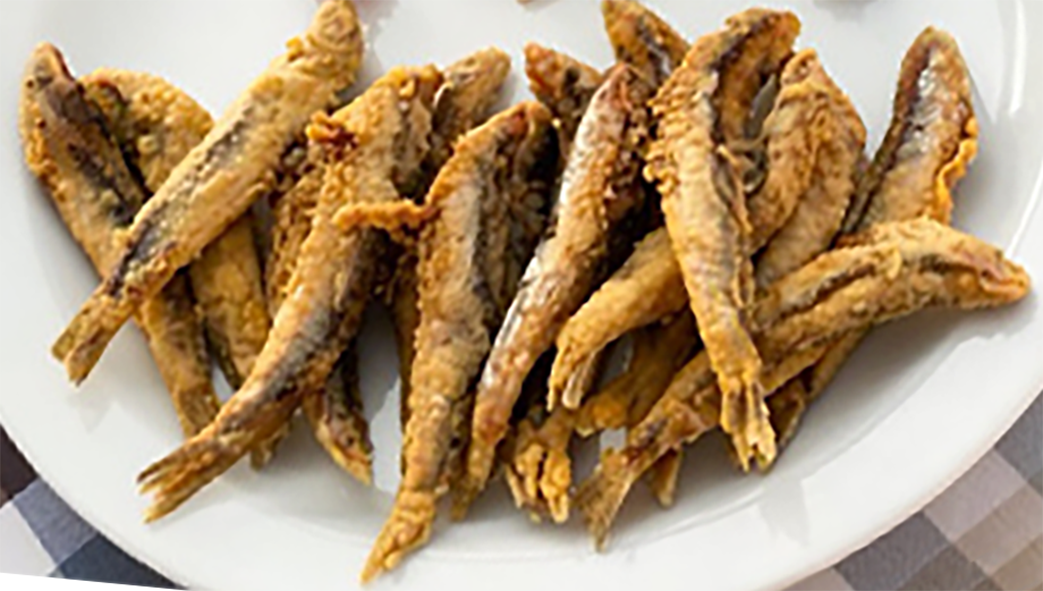 fried battered anchovies served on a plate