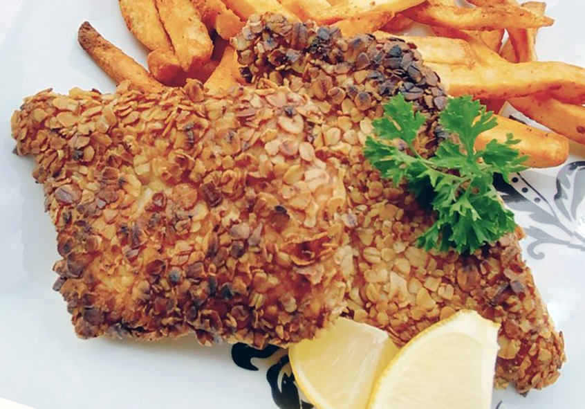 fish fillet with a dried sea lettuce and oatmeal crusting served with chips and lemon wedges
