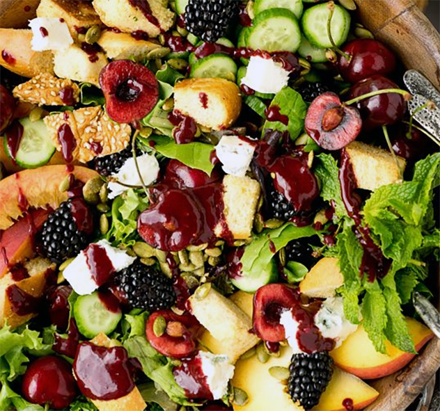 salad of mixed fruit, mint leaves and feta cheese in a balsamic vinegar and chasteberry dressing served drizzled with balsamic vinegar