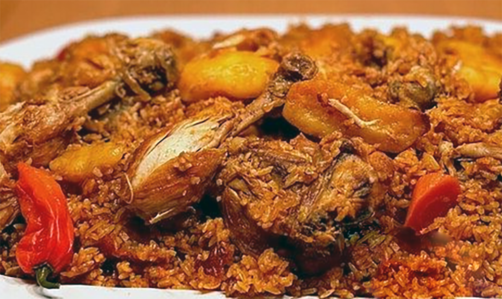 Gmabian chicken benachin of chicken and mixed vegetables served on a bed of rice