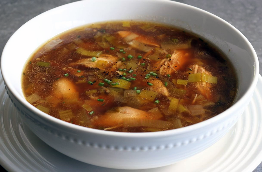 leftover game soup coloured with port in a white bowl