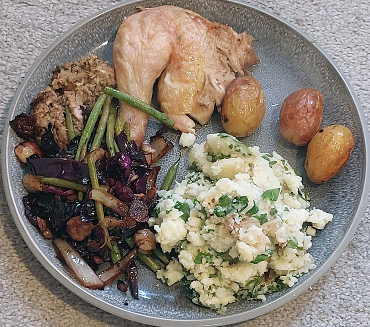 garlic mustard mash on a plate with stuffing, chicken leg, vegetables and roast potatoes