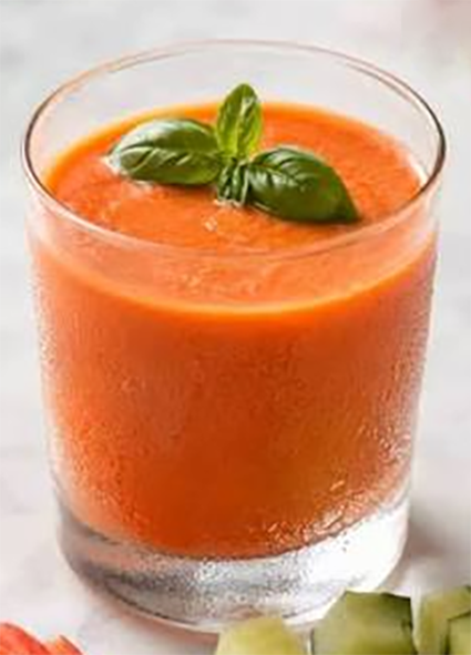 gazpachio smoothie in a glass garnished with a sprig of mint