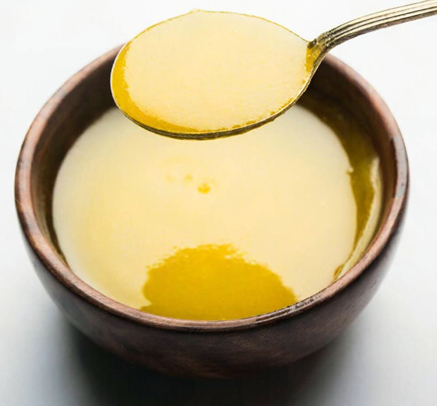 solidified ghee with a spoon in a small white bowl