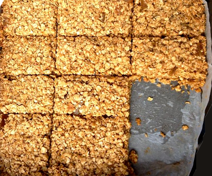 rectangles of ginger and marmalade flapjacks cooling in a square baking tin
