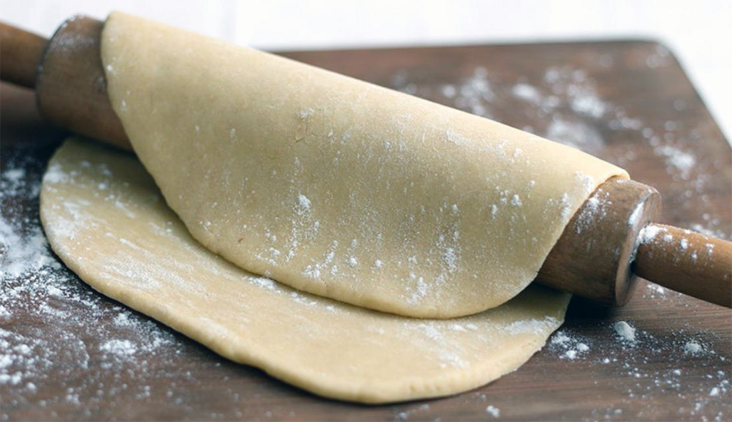 rich shortcrust pastry draped over a rolling pin