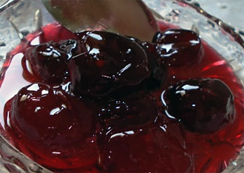 cherries preserved in syrup shown in a glass bowl