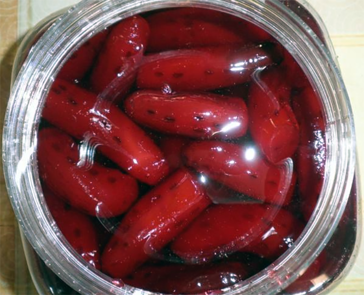 baby aubergines preserved in syrup presented in a jar
