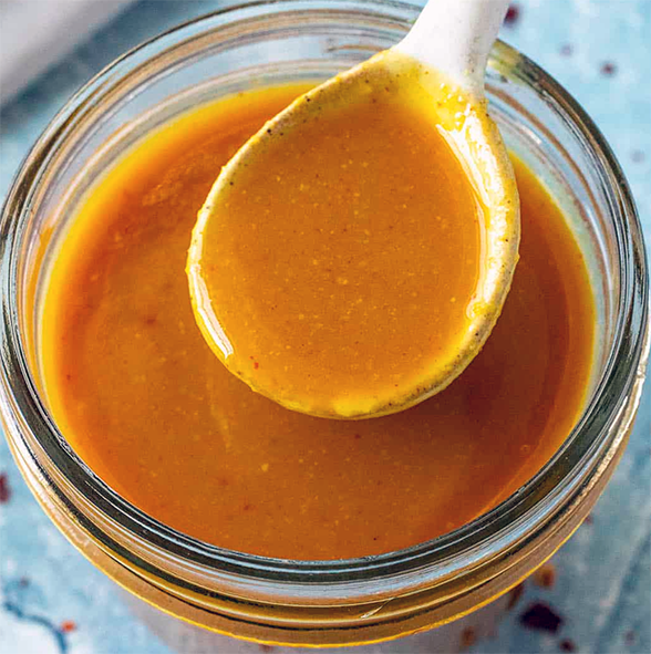 golden grill barbecue sauce in a glass dish with a spoon