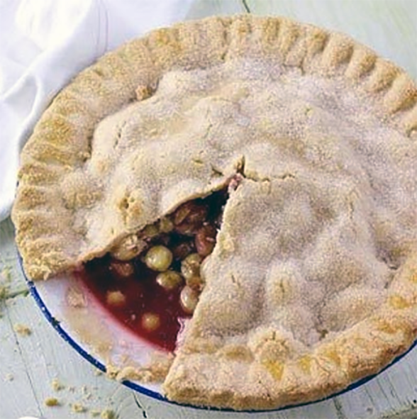 gooseberry and elderflower pie with a wedge removed to reveal the filling