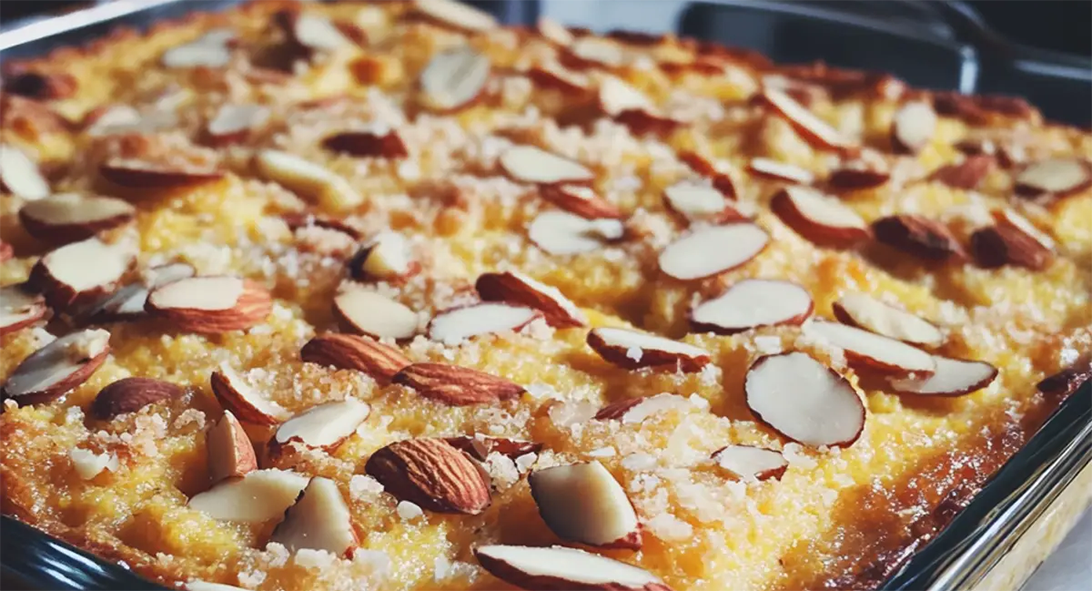 layered polenta with goosegrass filling baked in a glass dish with a slivered almond topping