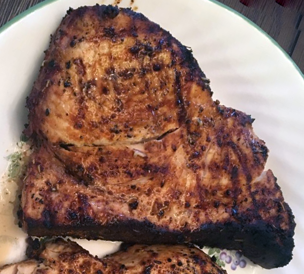 Barbecued swordfish steak with sherry, ginger and soy sauce marinade on a white plate