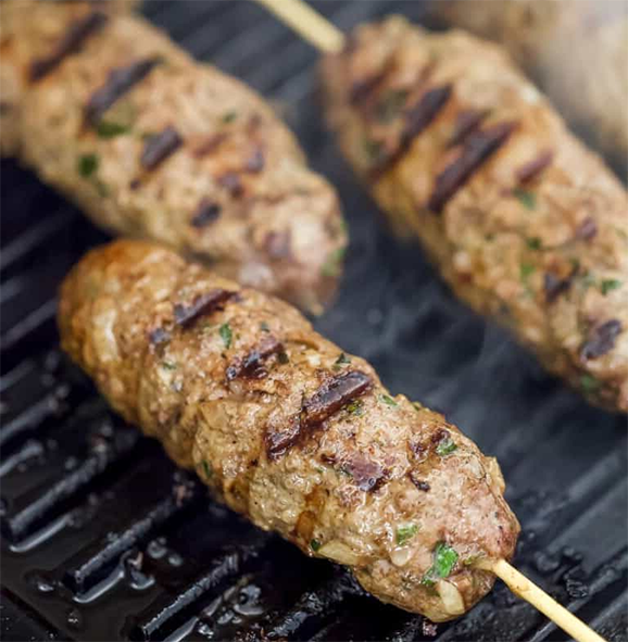 Moroccan lamb kefte kebabs cooking in a griddle pan