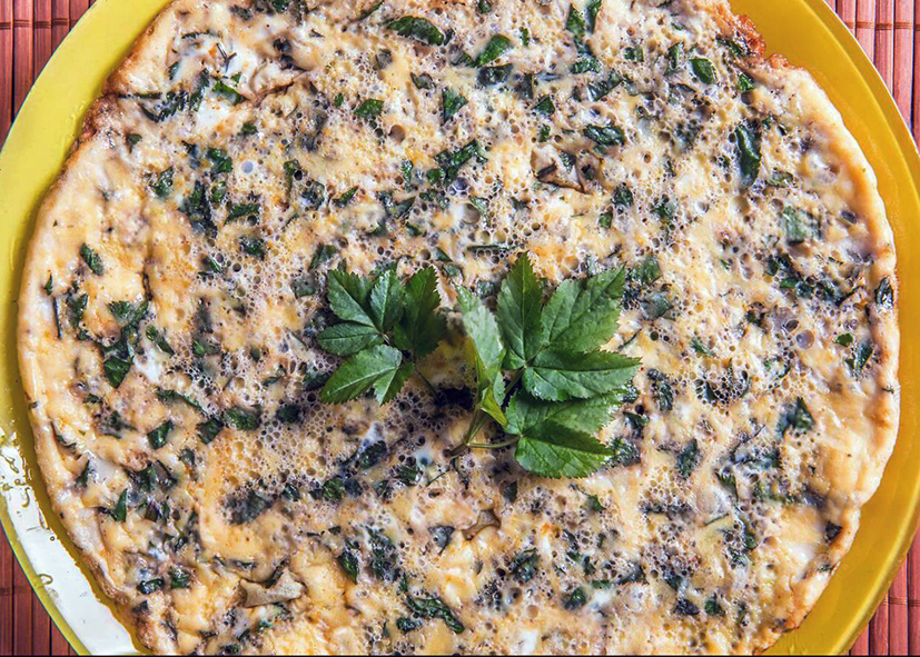 ground elder and potato omelette served on a plate garnished with a sprig of ground elder