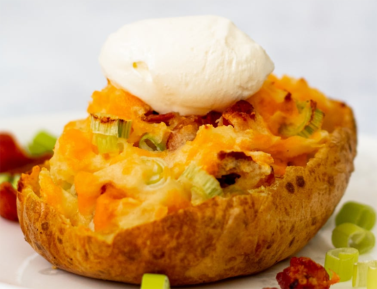 potato skin served with potato flesh fried with tomato puree, onion, chilli powder and mustard served topped with sour cream