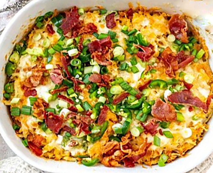 chicken and mashed potato hash garnished with spring onions in a baking dish