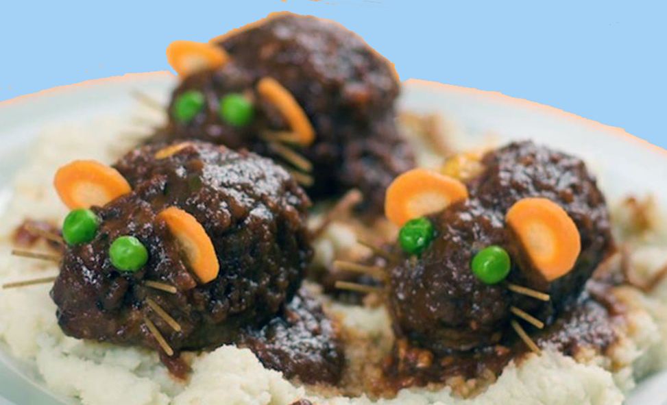 Halloween meatball mice served on a bed of mashed potatoes topped with spaghetti sauce