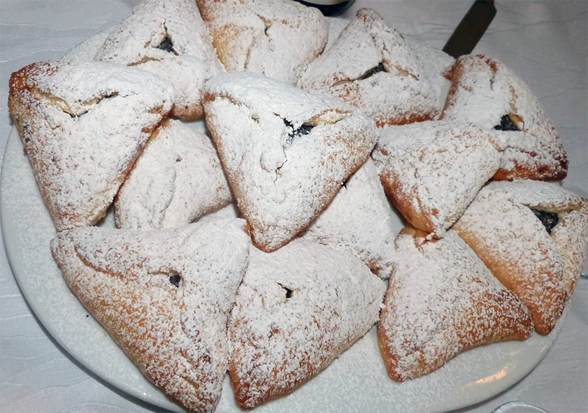 hamantaschen, filled tricorn pastries served dusted with powdered sugar