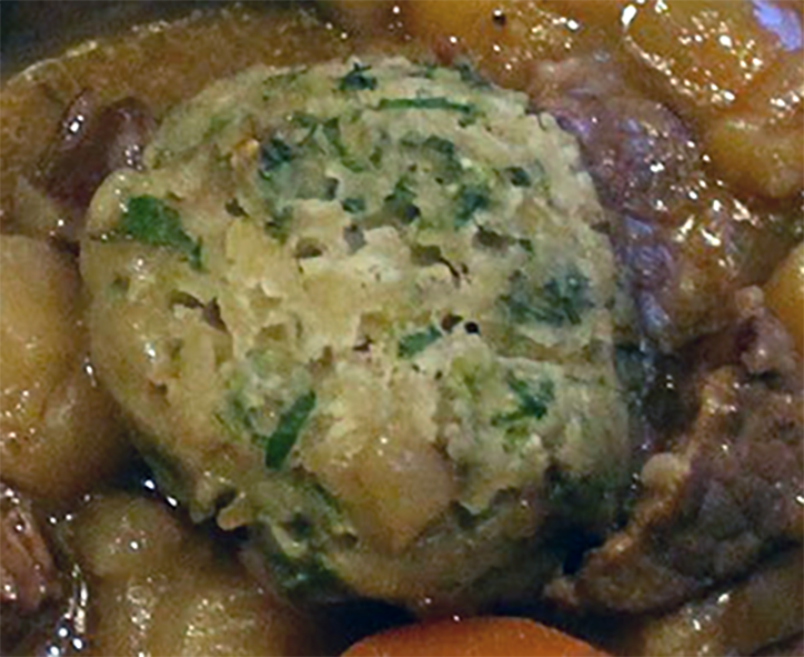 herby suet dumpling served on top of a stew