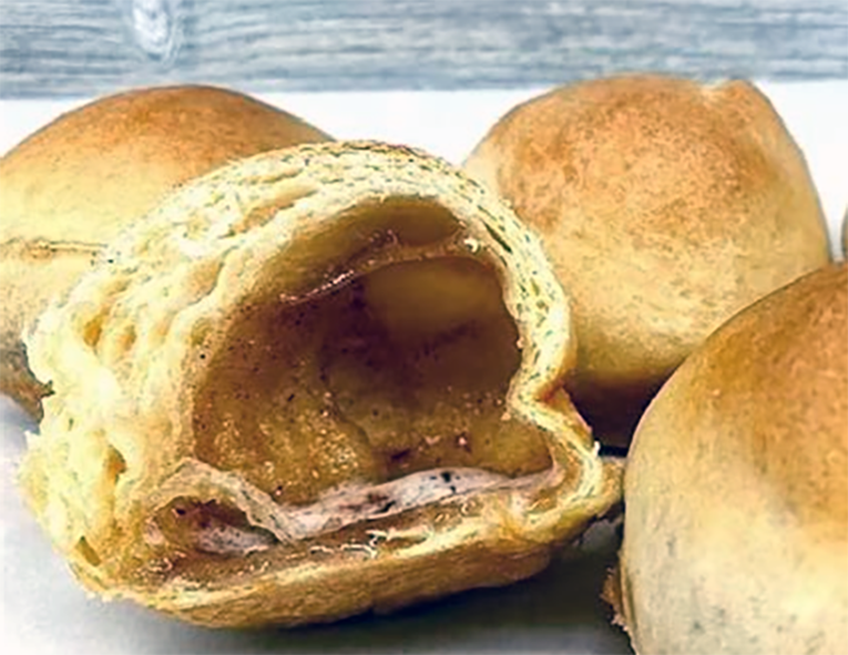 hocus pocus balloon buns with one split open to reveal the hollow centre