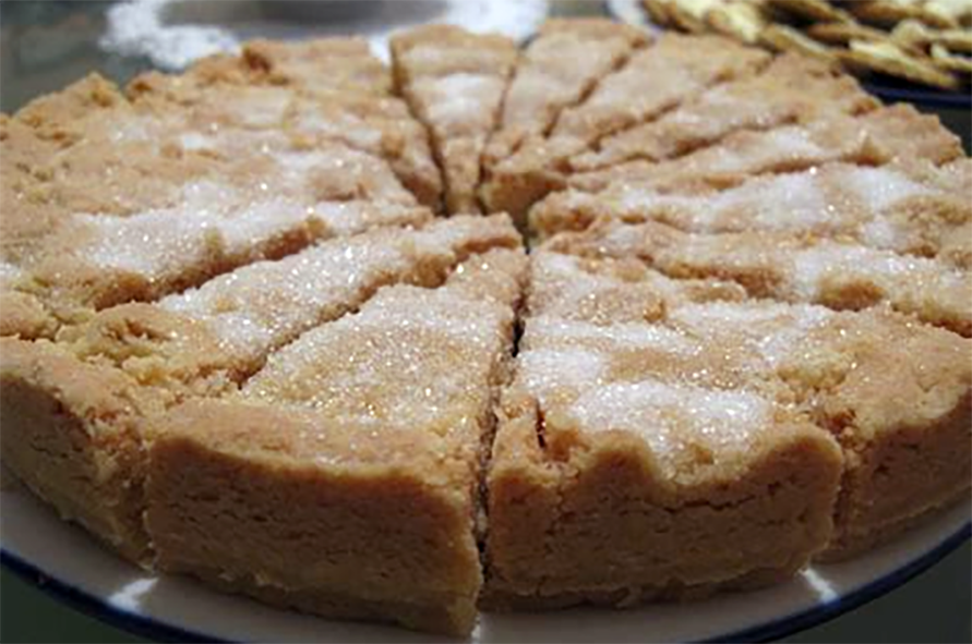 thick shortbread sliced as a cake and served on a cake dish, dusted with sugar, and ready for decoration</al>