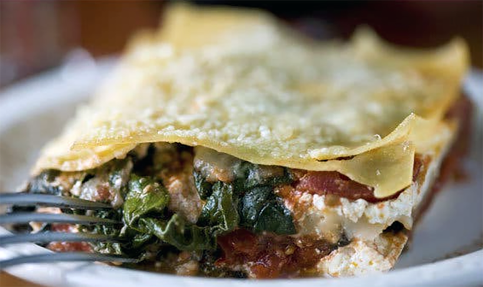 pancake filled with chard, onion and hogweed shoots in a tomato and parmesan sauce