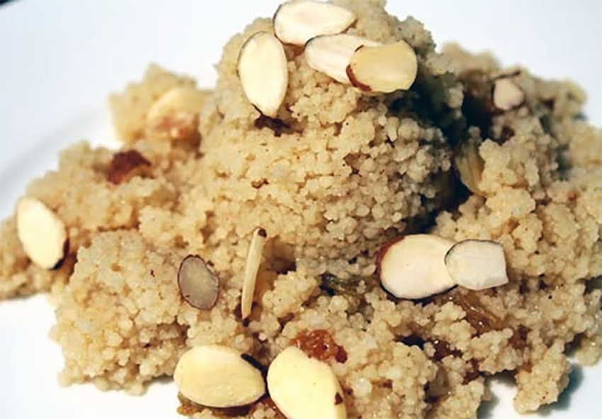 couscous cooked in honey and orange juice with sultanas served on a plate with slivered almonds