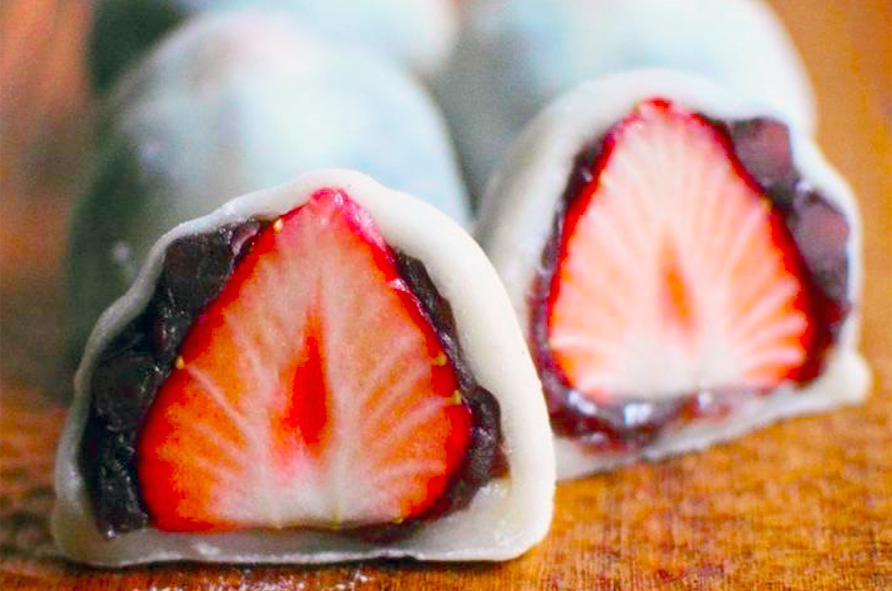 two japanese sweet rice cakes with a strawberry filling