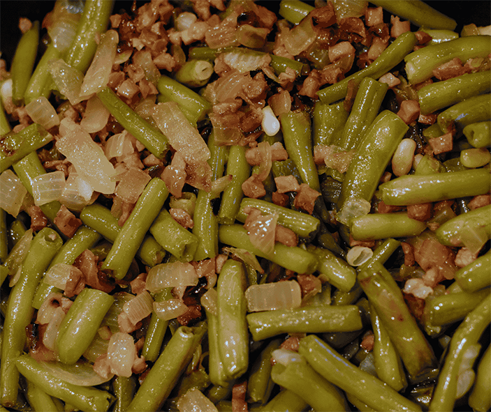 sliced boiled greens with diced ham in a garlic, onion and olive oil dressing