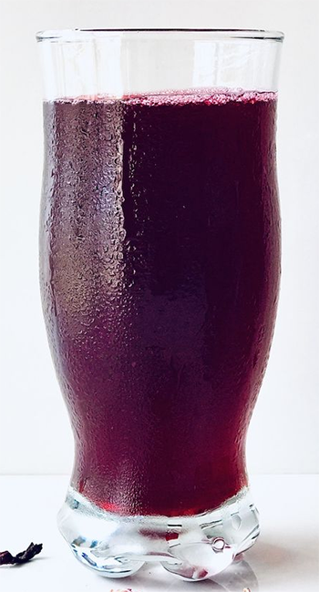 hibiscus flower and ginger drink in a tall glass