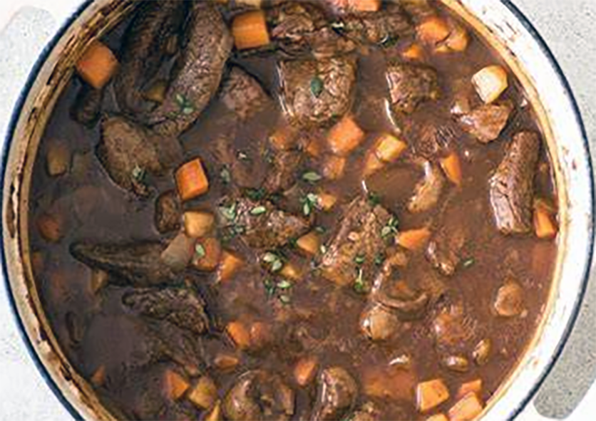 kidney and beef soup with carrots simmering in a cast iron casserole dish