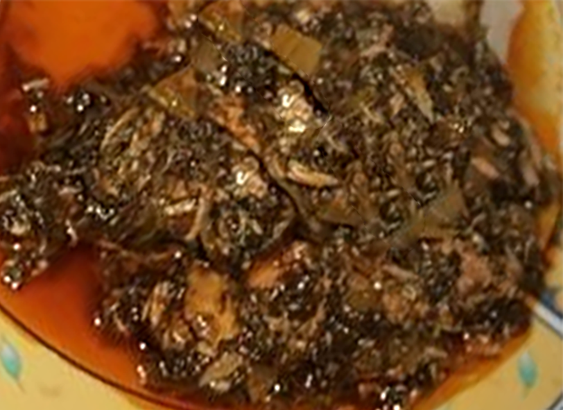 cassava leaf stew with dried fish in a red palm oil base