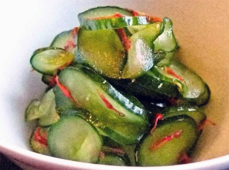 Japanese side dish of cucumbers and safflower petals in a light dressing served in a bowl