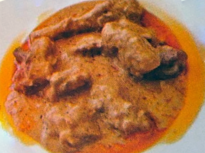 goat meat and prawns in a tomato and peanut sauce served on a plate