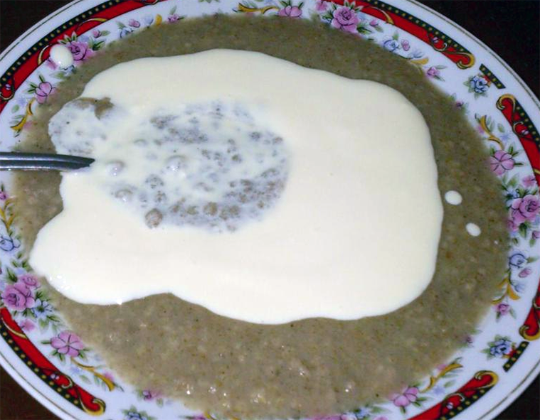 lakh porridge dessert in a bowl with a garnish of condensed milk