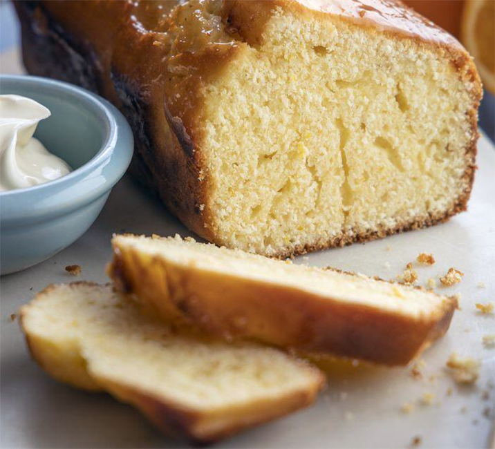 Lissanure lemon tea cake shown sliced on a chopping board with creamed white butter