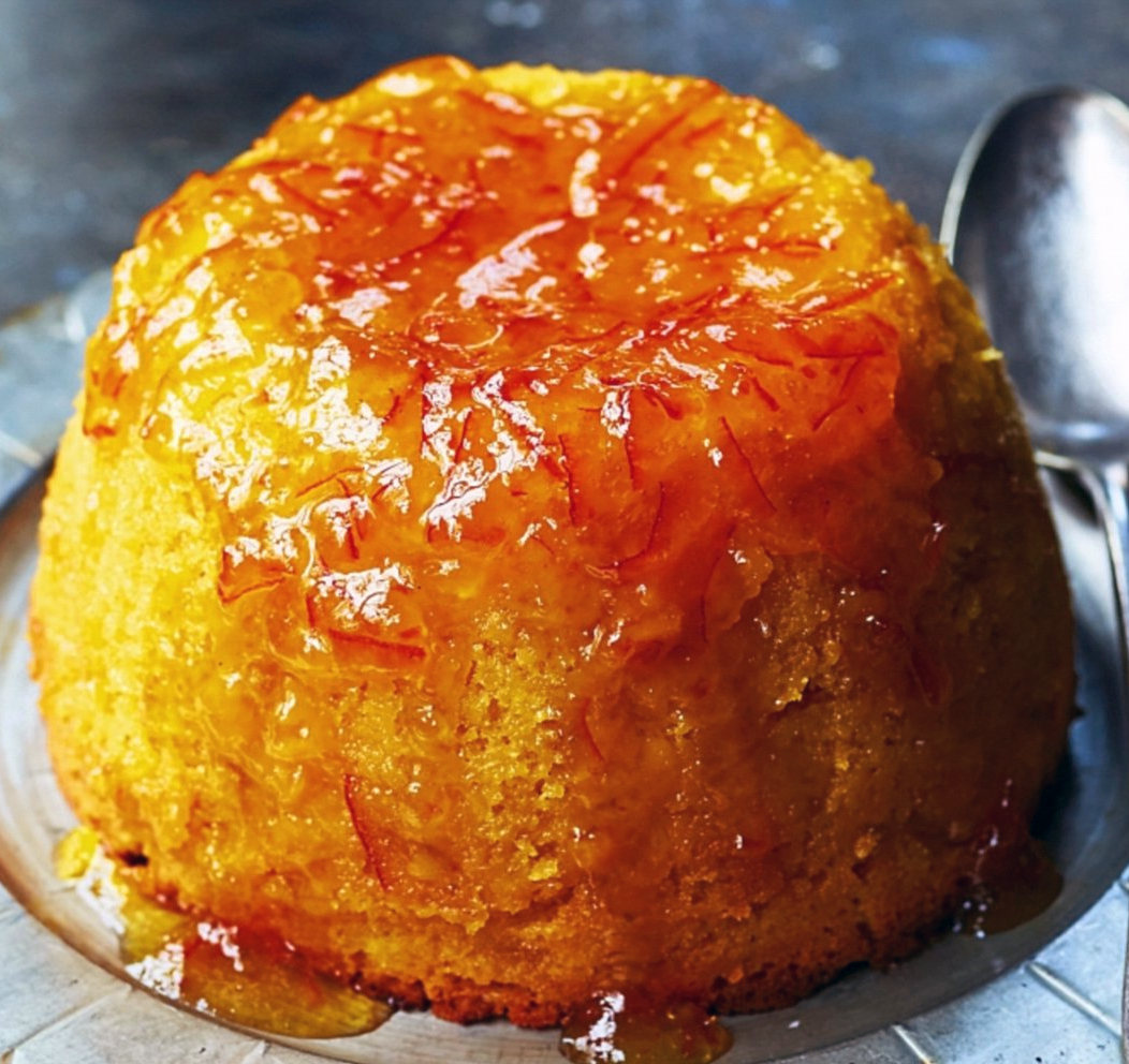 Steamed sponge pudding with a marmalade topping served on a metal plate