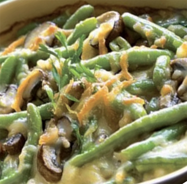 mean green bean casserole with mushrooms in white sauce in a casserole dish