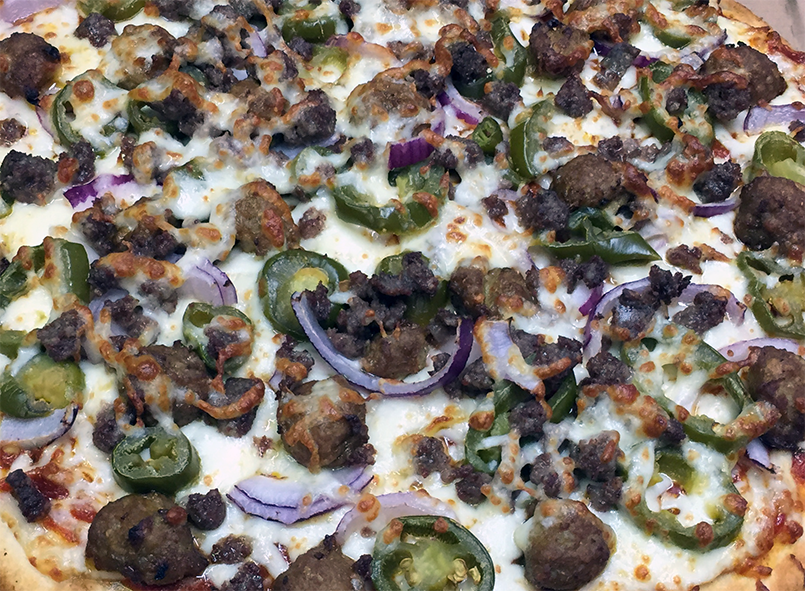 view across the centre of a meatball topped meat feast pizza