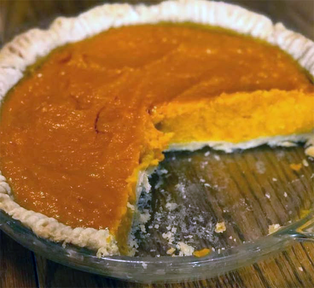 mississippi sweet potato pie with a wedge removed in a glass baking dish