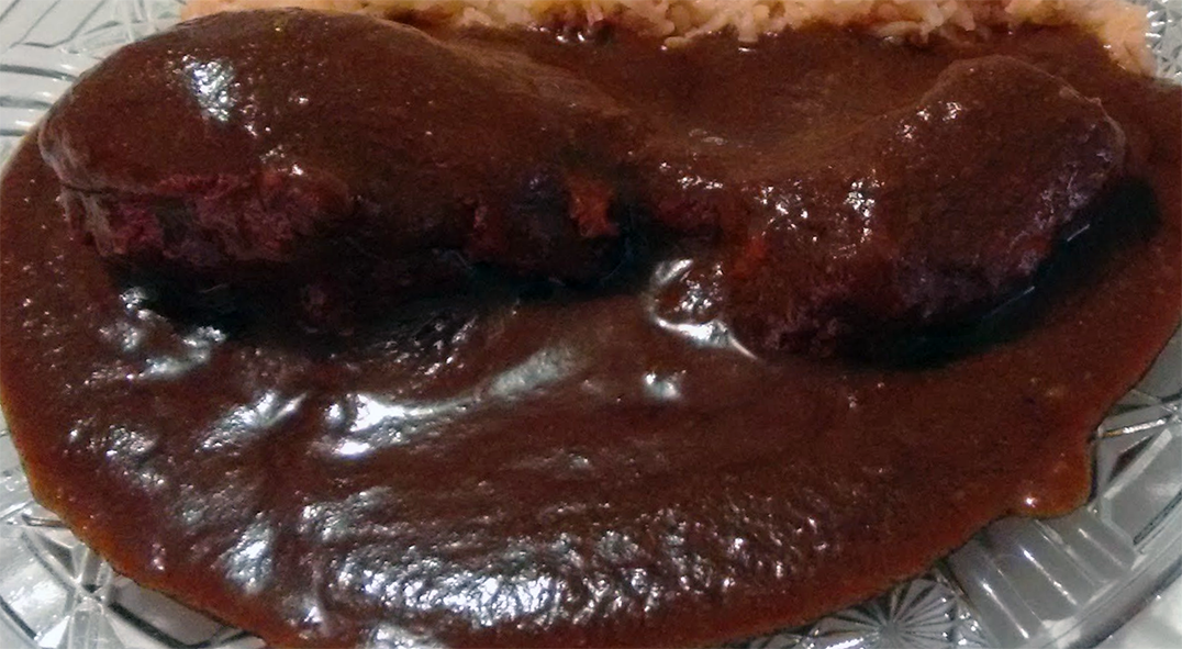 Chicken drumstick coated in red mole sauce