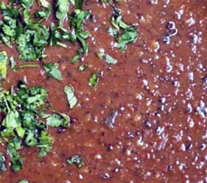 urad dal cooked to a porridge with tomatoes and chillies served garnished with chopped coriander