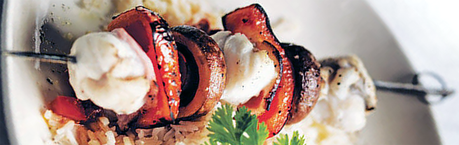 kepab of monkfish, red bell pepper, mushrooms and bacon on a bed of ride